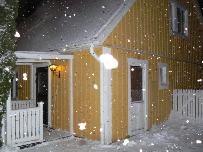 Snow falling on a yellow house; Foto: Andreas Rejbrand